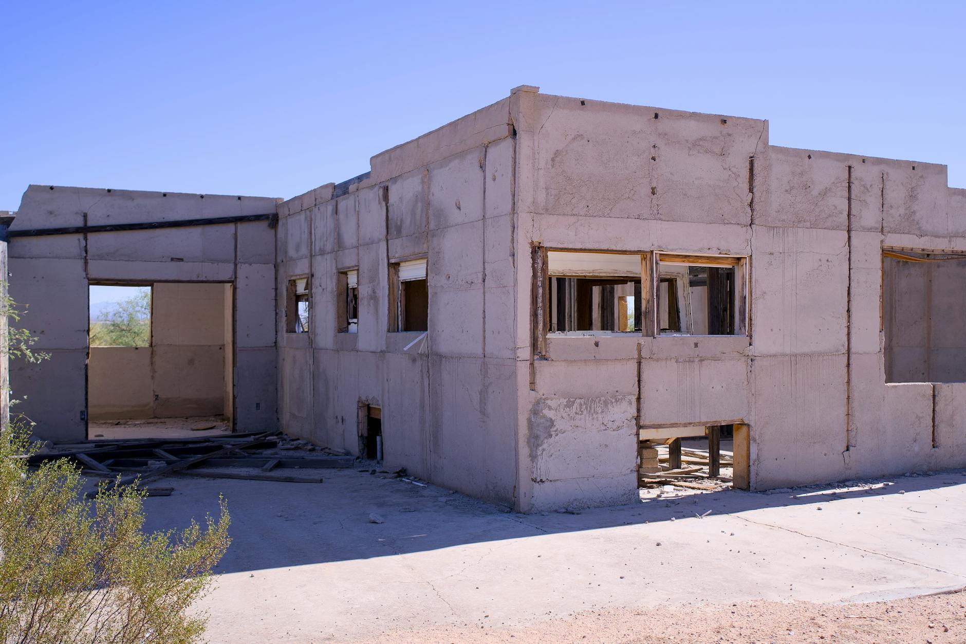 Arizona desert construction site with framed homes and a worker holding a clipboard at sunset