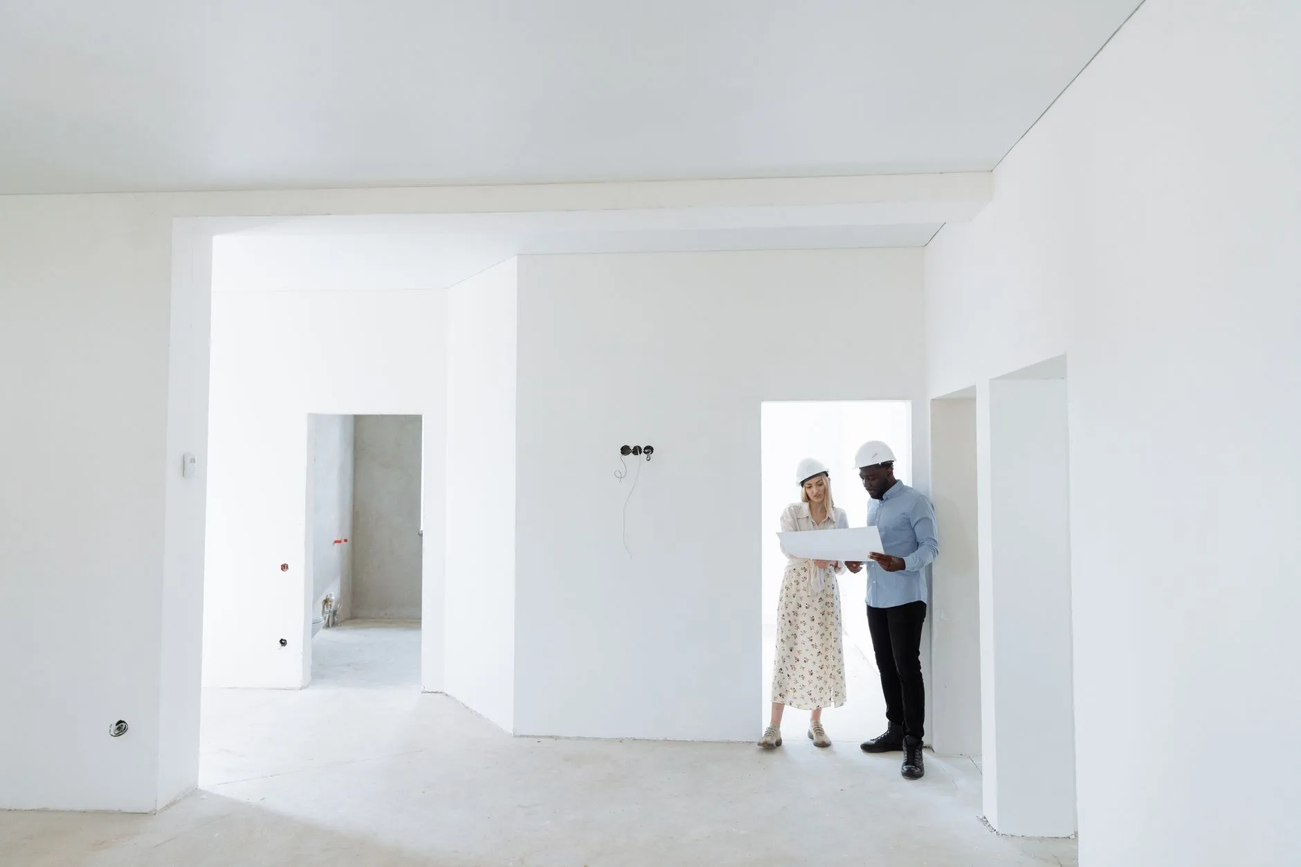 A contractor and homeowner reviewing a written change order form on a clipboard at a job site