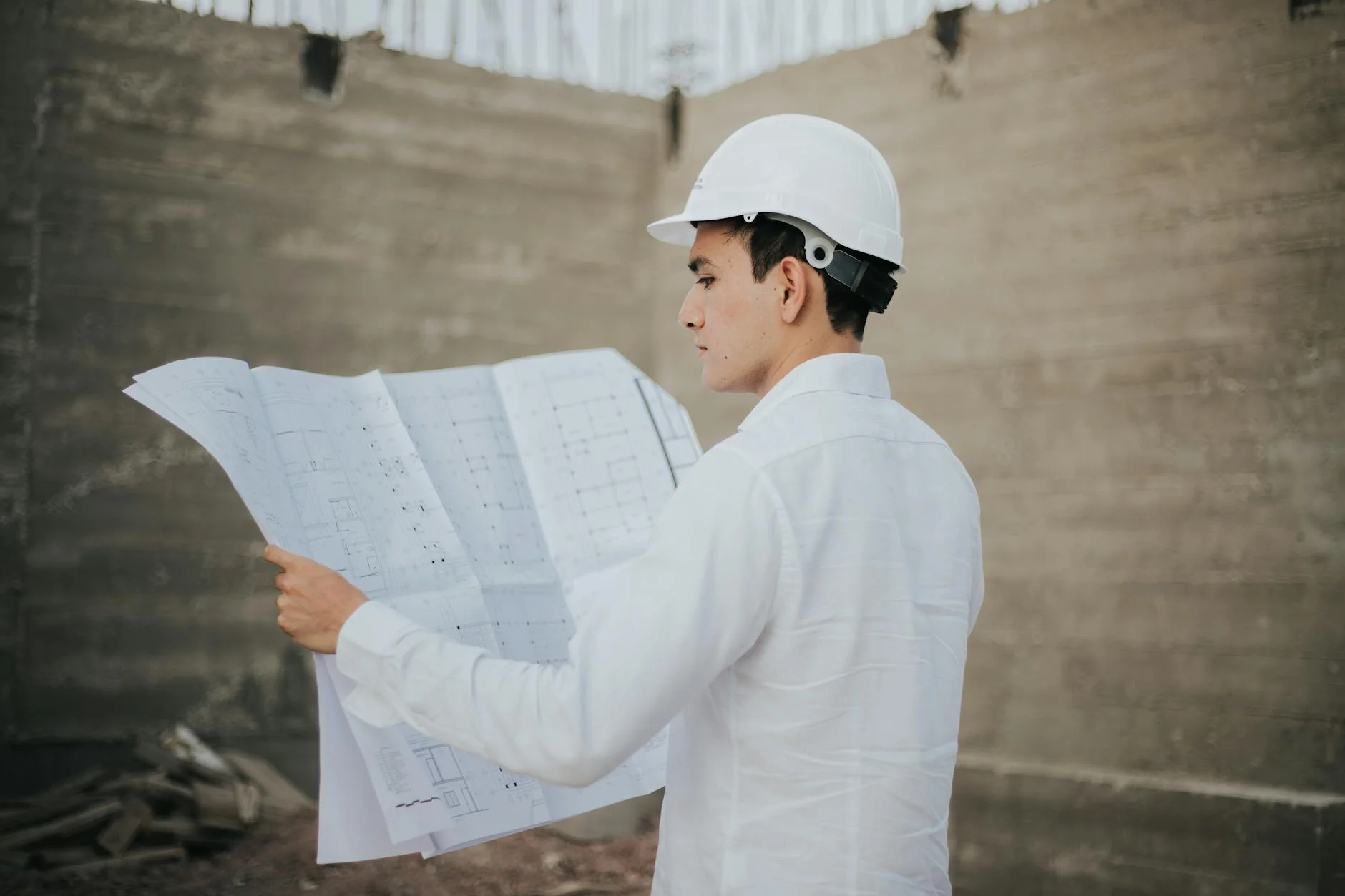Two construction workers in hard hats reviewing a clipboard at a project site
