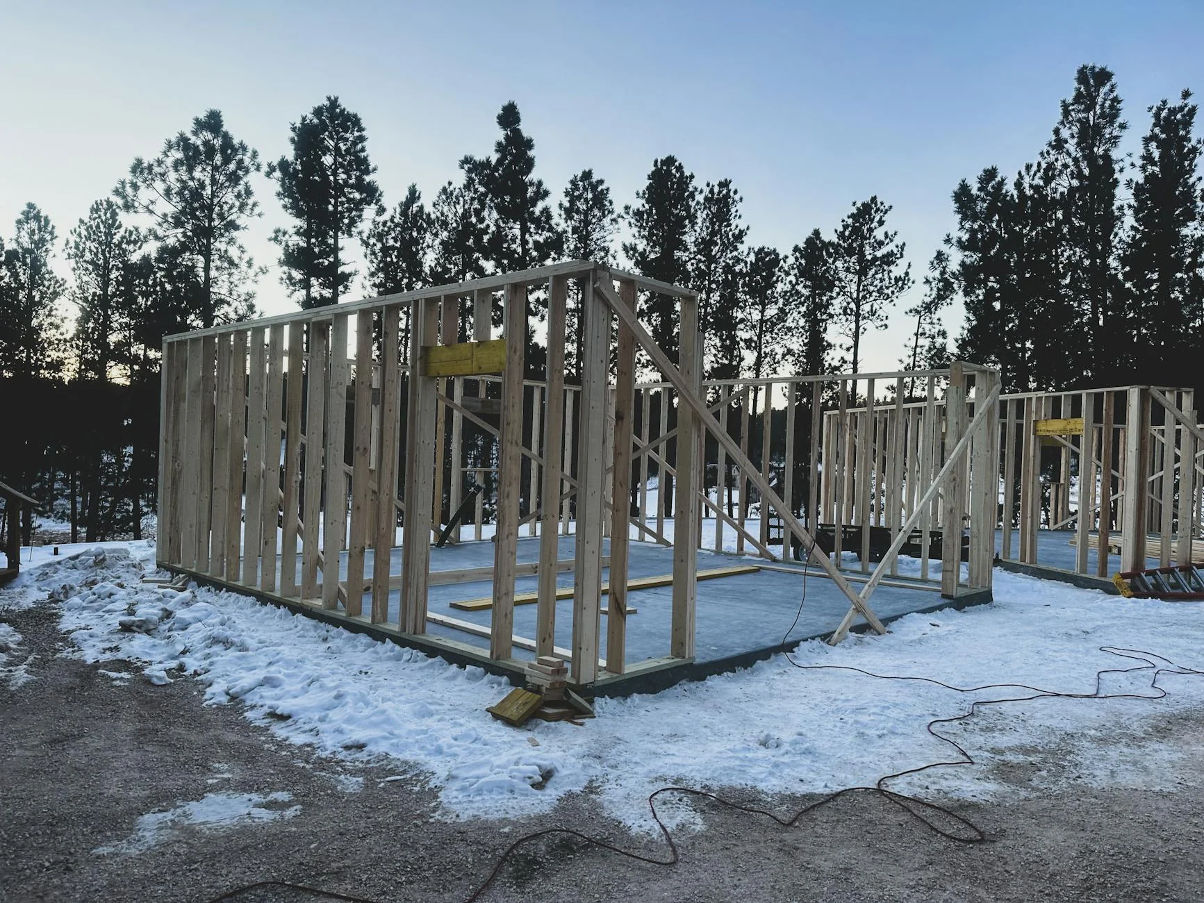 A general contractor on an Idaho residential job site reviewing paperwork on a tailgate, mountains in the background
