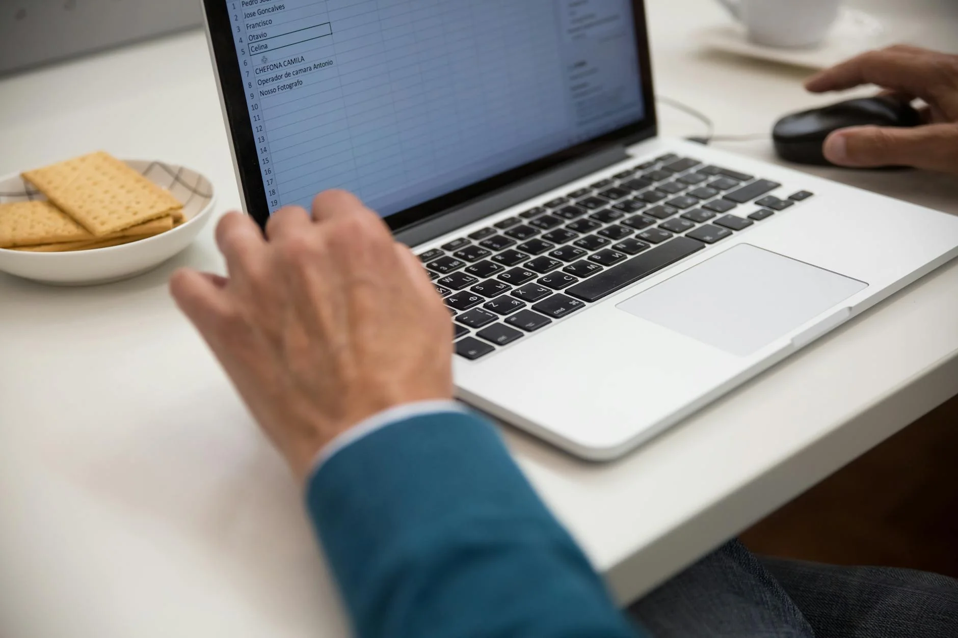 General contractor tracking lien waivers in a spreadsheet on a laptop at a desk