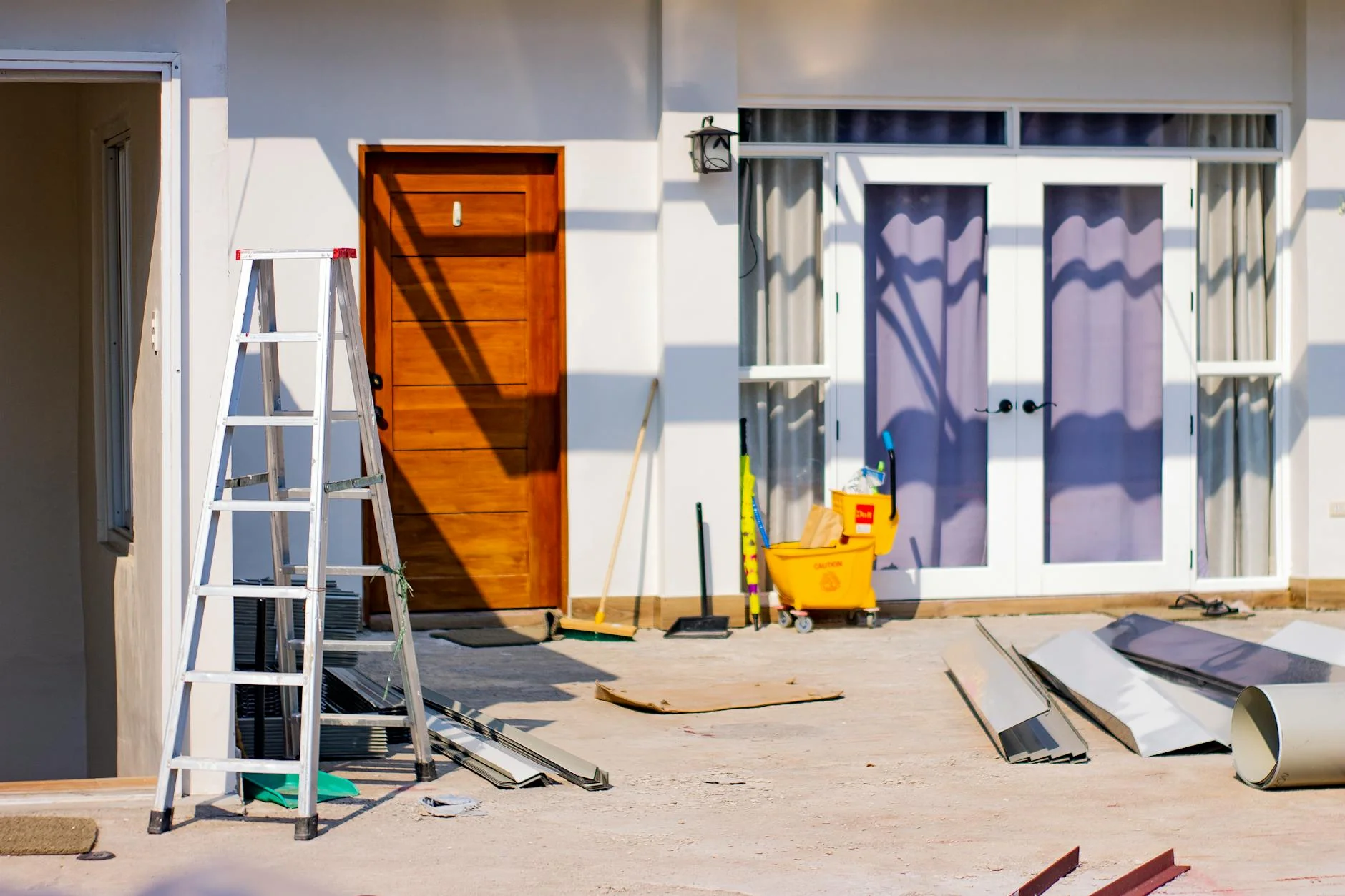 Homeowner reviewing paperwork on the porch of a finished renovation