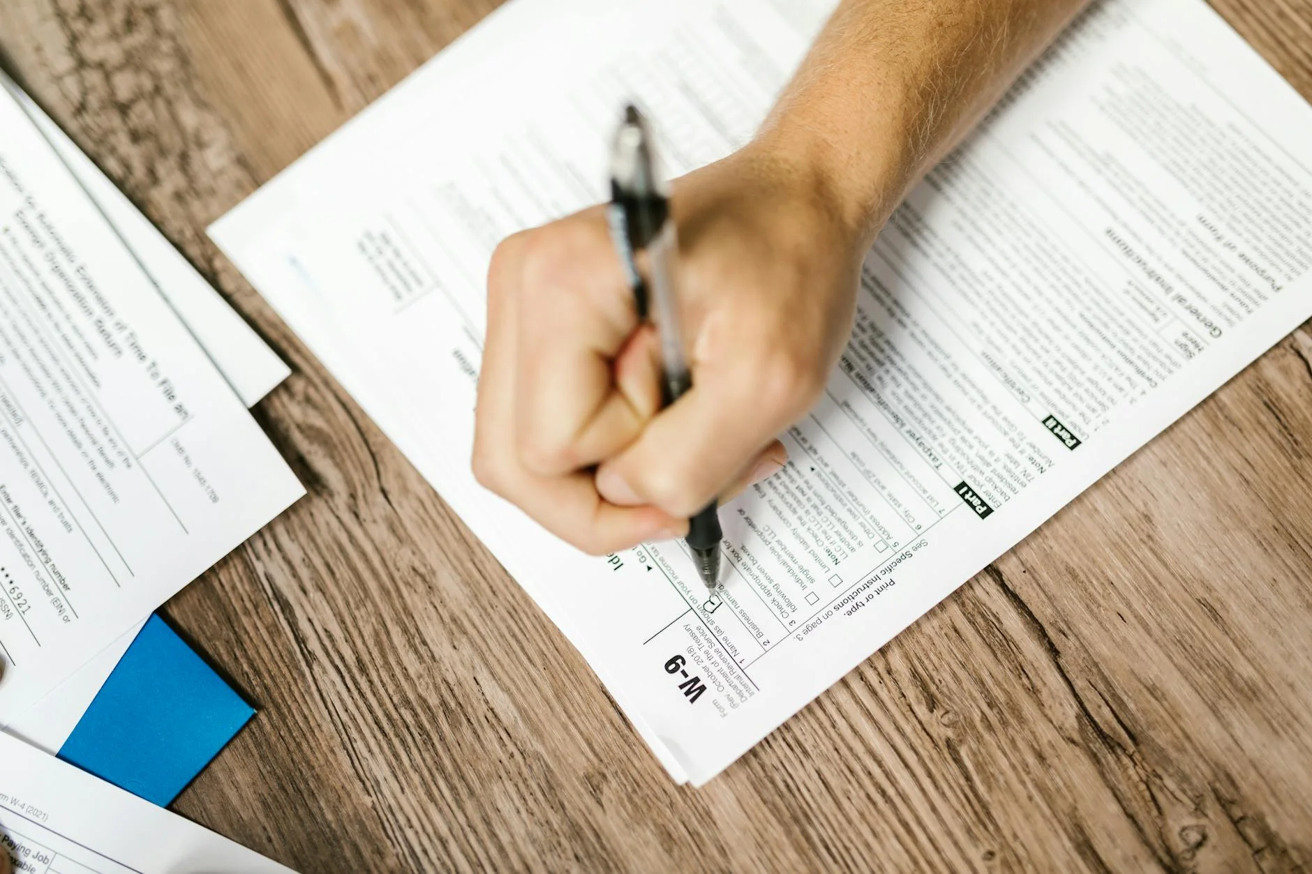 A subcontractor signing a lien waiver document on a clipboard at a construction site